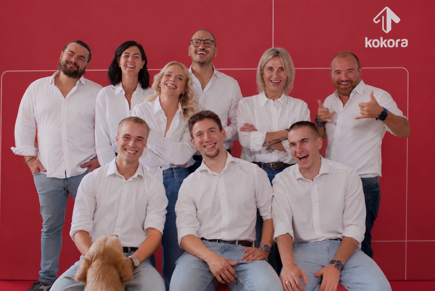 Il team Kokora al completo davanti al backdrop rosso brandizzato